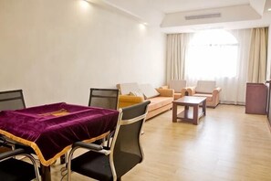 A living room with a dining table, chairs, a sofa, and a coffee table. - Fuhao Hotel Suichuan (Suichuan)