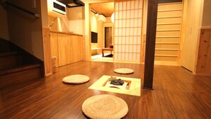 Une pièce de style japonais traditionnel, avec un sol recouvert de tatamis, une basse table en bois et une porte coulissante.