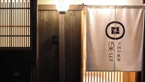 Une pièce avec une porte en bois et un rideau orné d’un logo et d’un texte en japonais.