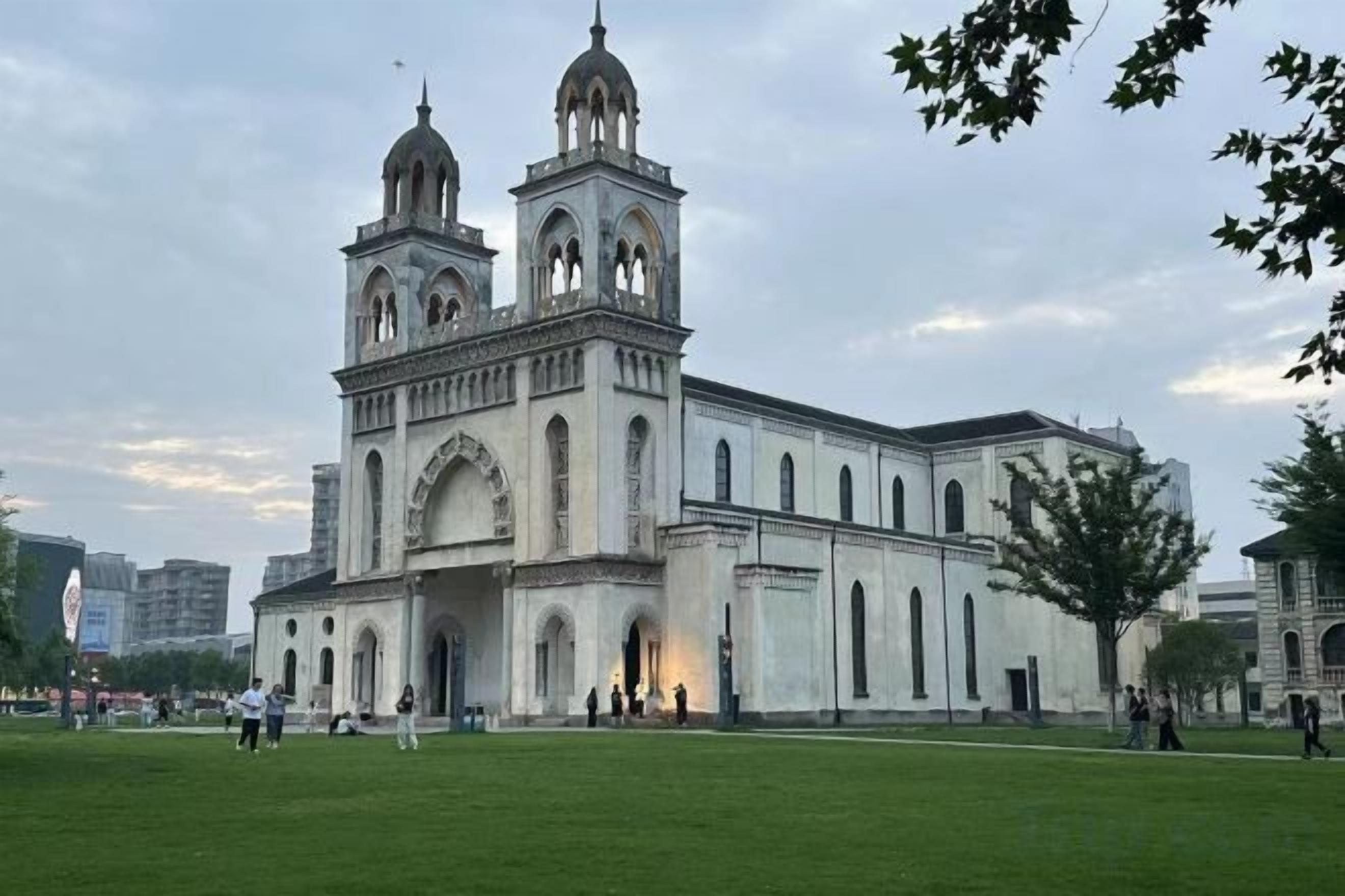A large, historic building with two prominent towers and a central arched entrance.