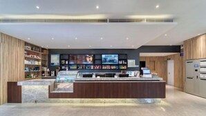 A modern reception area with a marble counter, wooden shelving, and a digital display. - HanTing Hotel (Jiaxing Nanhu Yaohan Shopping Mall Area) (Jiaxing)