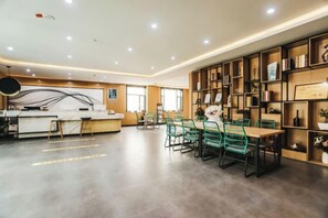 A modern interior with a reception desk, seating area, and bookshelves. - Shankee Tea Style (Ancient City of Kashgar Xiyu Avenue Food Street) (Kashgar City)