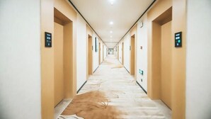 A long, narrow hotel corridor with doors on both sides, each marked with a sign indicating room numbers. - Shankee Tea Style (Ancient City of Kashgar Xiyu Avenue Food Street) (Kashgar City)