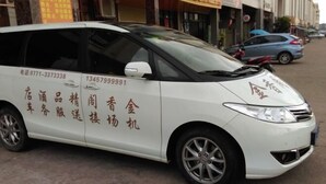 Una camioneta blanca estacionada en una calle con texto en chino en su lateral.