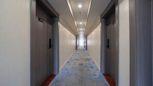 Un pasillo largo y estrecho con puertas a ambos lados, cada una con un número.