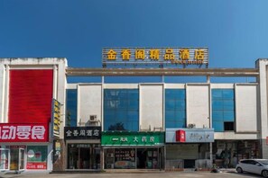 Un edificio con varias fachadas, que incluye una farmacia y un restaurante.