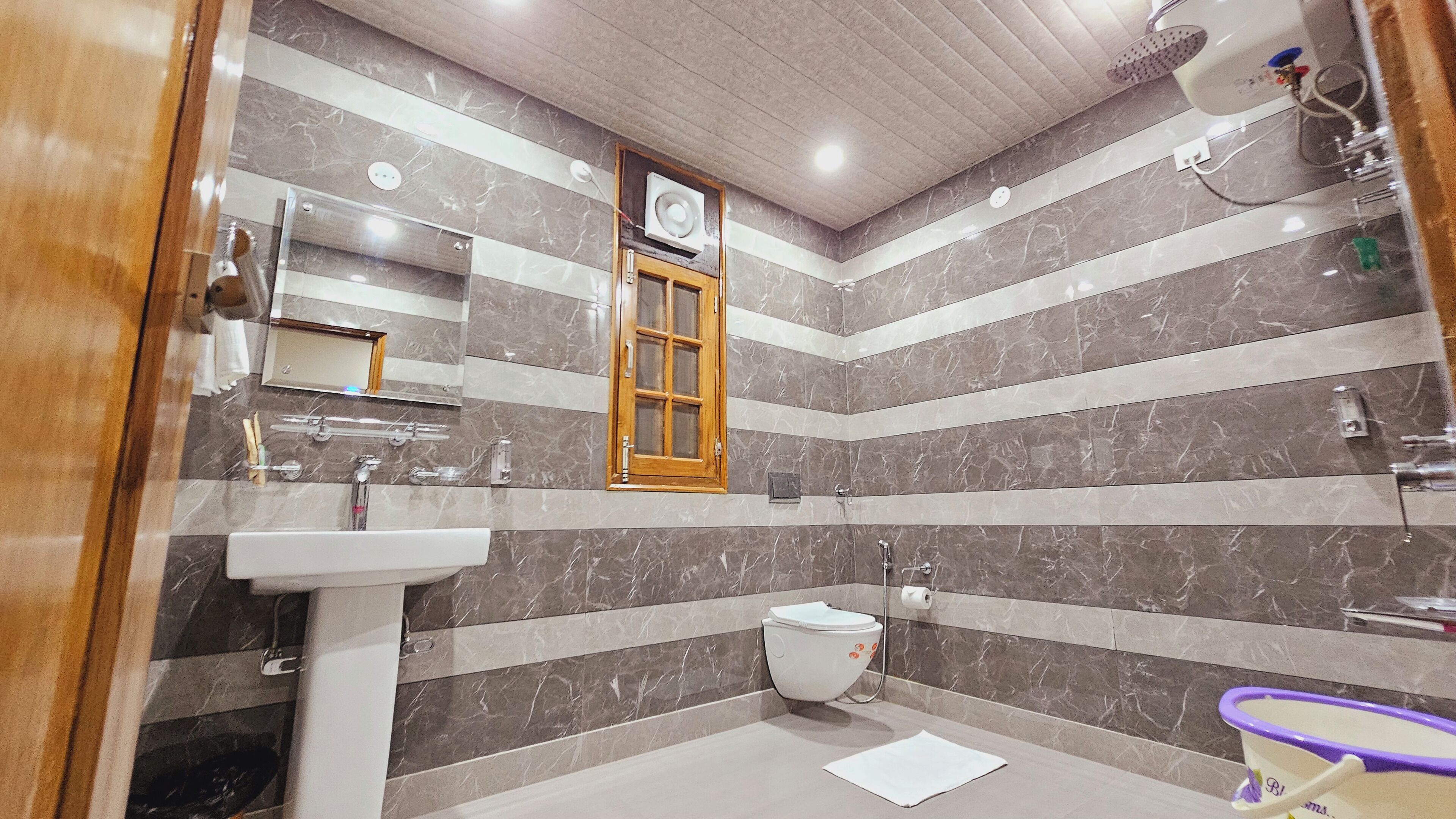 Une salle de bain avec un lavabo, des toilettes et une douche.