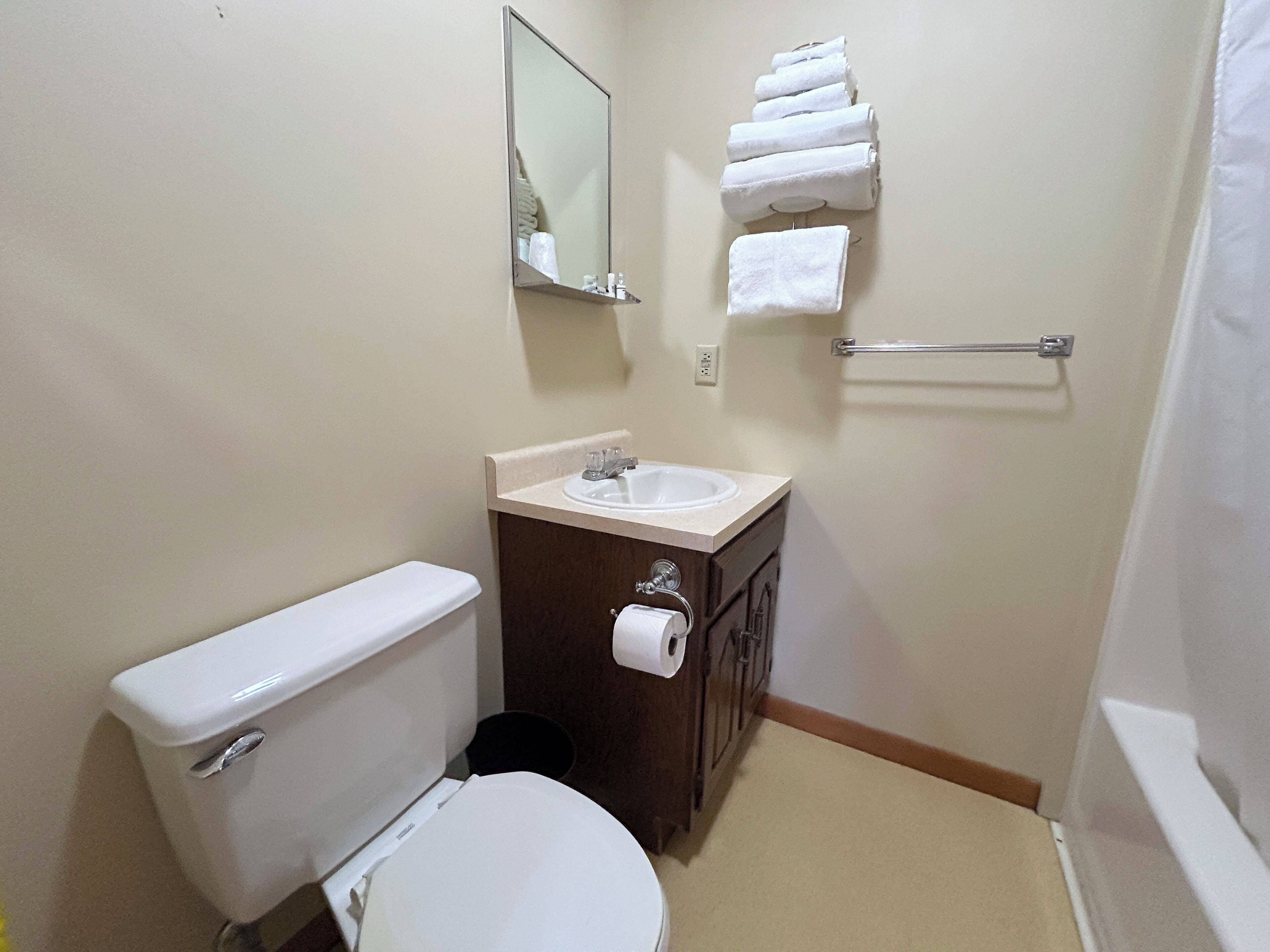 A small bathroom with a toilet, sink, and a towel rack.