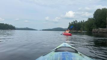 A kayak on calm water with a person paddling.