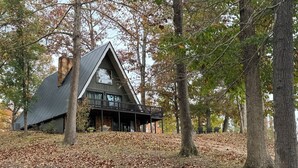 Eine Holzhütte mit steinernen Fundamenten, einem geneigten Dach und einem Balkon.