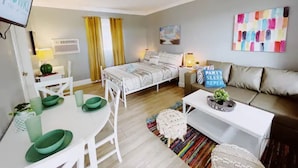 Une chambre moderne et bien éclairée, avec un lit, une table de chevet et un canapé.