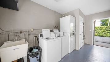 A laundry room with a washing machine, dryer, and a utility sink.