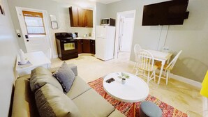 A compact living space with a kitchenette, a dining area, and a seating area with a sofa and a small table. - Cozy 1 Bedroom APT 1 block off the beach W/ pool (pompano beach)