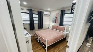 A bedroom with a bed, bedside tables, a desk, and a window with curtains. - Stylish & Convenient 2 BR Apt (Fort Lauderdale)