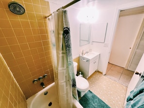 Un baño con bañera, inodoro, lavabo y cortina de ducha.