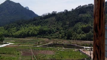 A view of a mountainous landscape with a river and terraced fields.