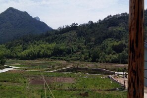 Vista de un paisaje montañoso con un río y campos en terrazas.