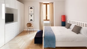 A bedroom with a bed, a chair, a TV, and a radiator. - Apartments Florence - The Wizard's House (Firenze)