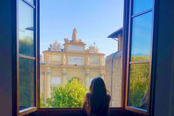 A room with a large window offering a view of a historic building with statues and ornate architecture.