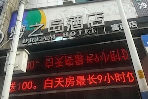 A hotel sign with Chinese characters and a neon sign below it.