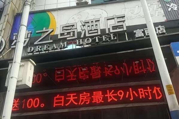 A hotel sign with Chinese characters and a neon sign below it.