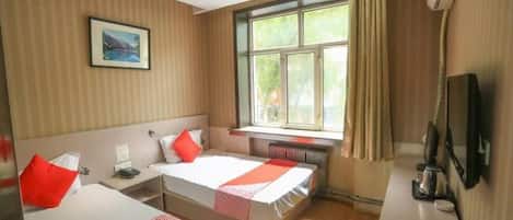 Habitación de hotel con dos camas, una ventana con cortinas, un escritorio con una silla, un televisor y un cuadro en la pared.