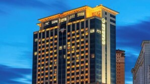 A high-rise building with multiple floors, large windows, and a prominent entrance at the top. - Zhaofeng International Hotel (Kuancheng)