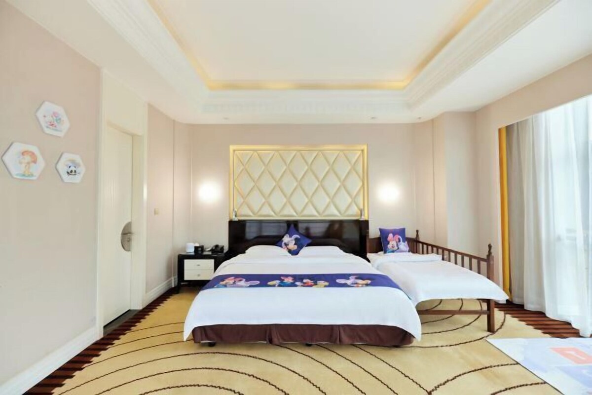 Habitación de hotel con una cama grande, una mesita de noche, un cabecero decorativo y una ventana con cortinas.