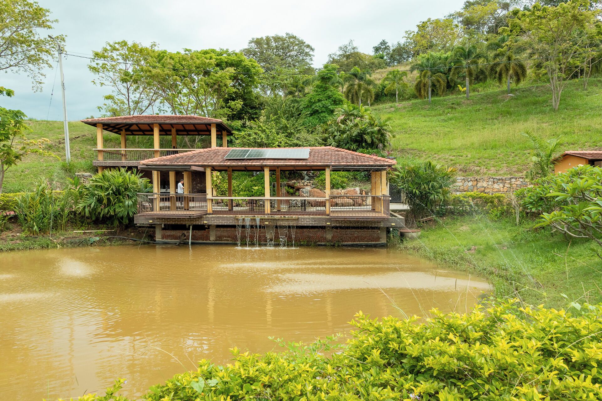 A two-story building with a wooden deck and a small waterfall feature.
