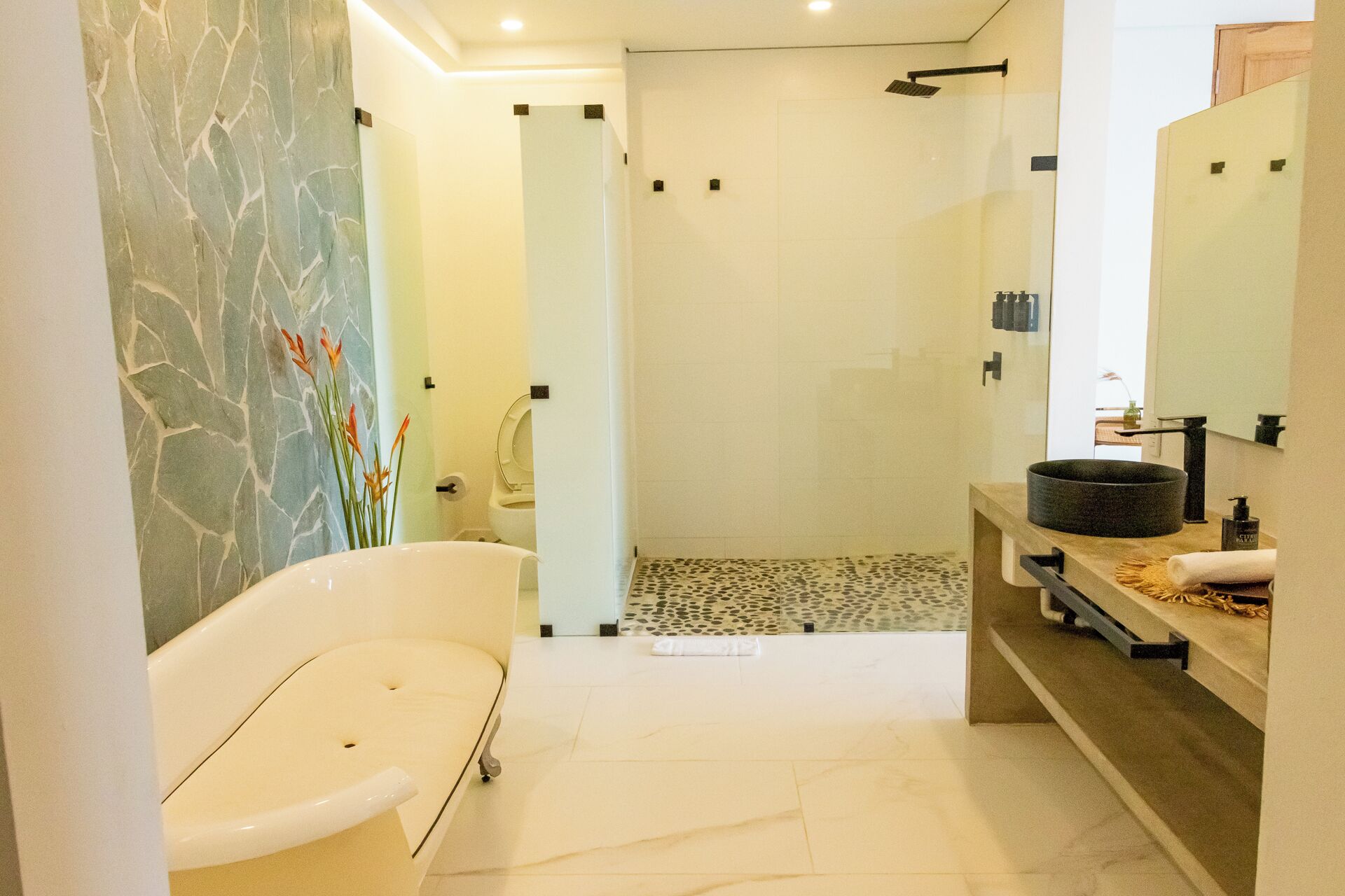 Un baño moderno con una bañera independiente, zona de ducha y tocador con espejo.