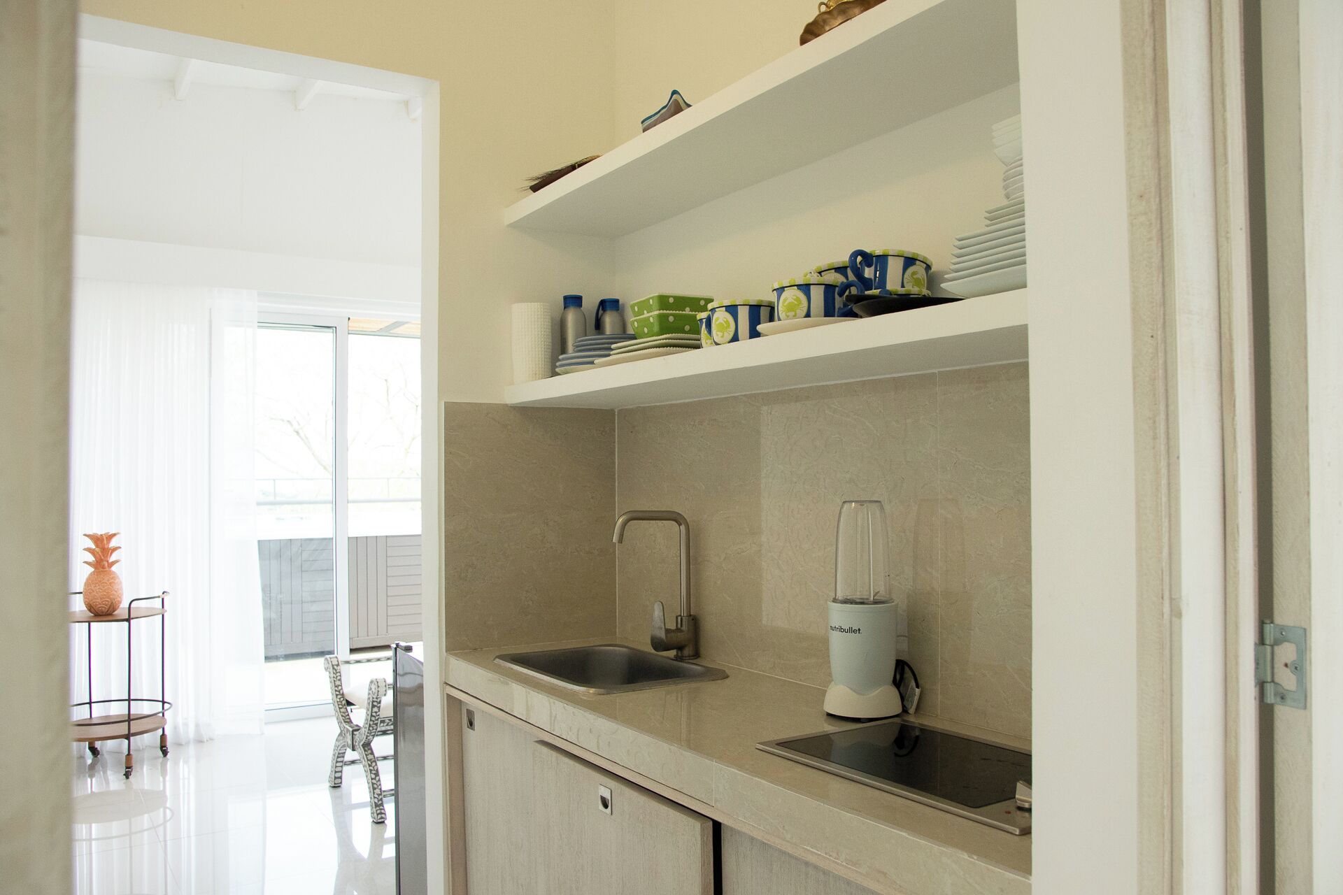 Una cocina moderna con un lavamanos integrado, una licuadora y un comedor con mesa y sillas.