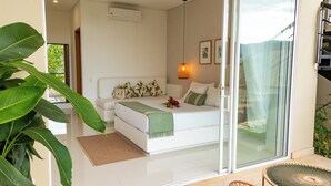 Un dormitorio moderno con una cama grande, un ventanal corredero a un balcón y vistas al exterior.