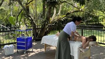 Relax in a serene natural setting, surrounded by lush greenery, with access to massage therapy and wellness activities.
