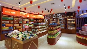 Un magasin bien éclairé, avec des étagères remplies de divers produits, notamment des en-cas et des boissons.