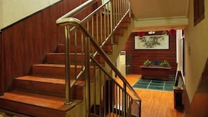 Un escalier en bois avec des rampes en métal menant à un niveau inférieur.