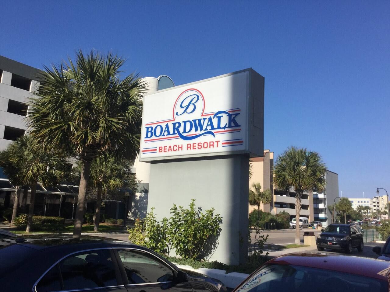 Skiltning for Boardwalk Beach Resort med en moderne bygning i baggrunden.