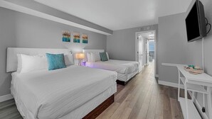 A hotel room with two beds, a TV, and artwork on the wall.