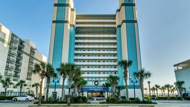 A mid-rise hotel with a central atrium, multiple floors, and a prominent 'Boardwalk' sign at the ground level.