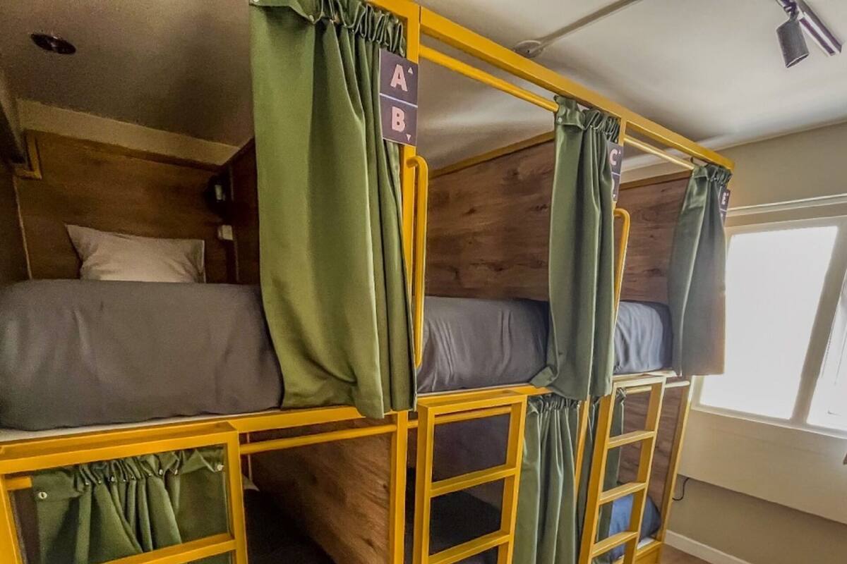A bunk bed room with green curtains and a sign indicating 'A' and 'B' sections.