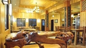 Un intérieur en bois comprenant un coin repas avec des tables et des chaises en bois.