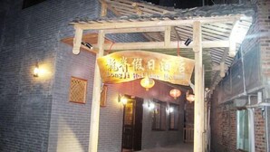 Il s’agit d’un bâtiment traditionnel chinois, doté d’un auvent en bois au-dessus de l’entrée et d’une enseigne indiquant qu’il s’agit d’une maison de vacances.