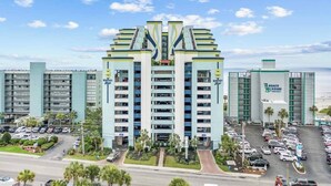 Un hôtel à plusieurs étages au design moderne, doté d’un atrium central et de nombreux balcons.