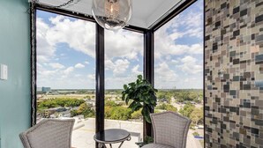 A balcony with two chairs, a small table, and a potted plant.