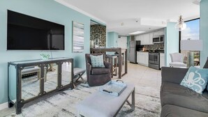 A modern living room with a TV, sofa, and dining area.