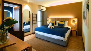 A modern bedroom with a large bed, bedside lamps, a mirror, and a wooden floor. - My Bed Gold Hotel (Chonburi)