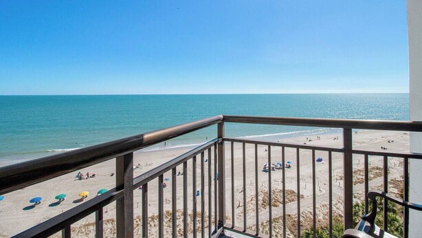 A balcony with a view of a beach and the ocean. - Beach Getaway Oceanfront/ Dogs OK! (Myrtle Beach)