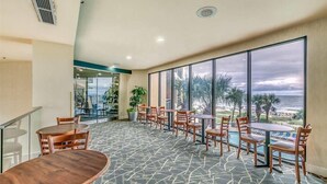 A spacious indoor area with a pool, large windows, and a view of the ocean. - Paradise Awaits @ Oceanfront Suite/Dogs OK! (Myrtle Beach)