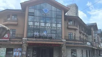 A hotel with a prominent sign, a balcony, and a storefront below.