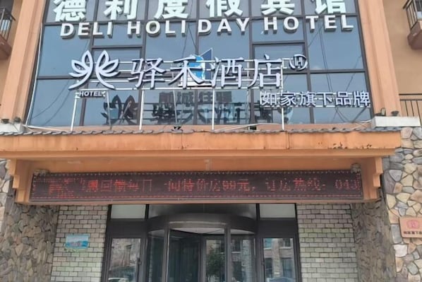 A hotel sign with 'DELI HOLIDAY HOTEL' and another sign with Chinese characters.