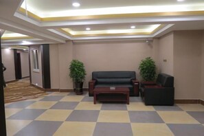 A lobby with a checkered floor, a sofa, a coffee table, and two potted plants. - Home Inn Yihe Hotel (Changbai Mountain West Scenic Area Distribution Center Store (Fusong)